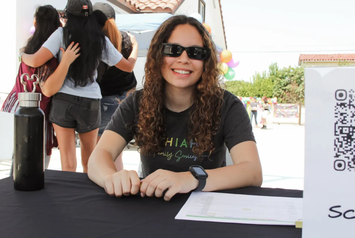 Pitzil Avila-Castellanos at a Bithiah's Family Services volunteer table during a community event